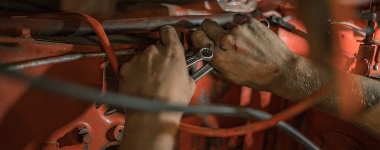 Hands working on wiring inside a vehicle